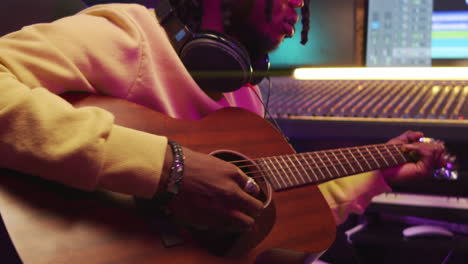 African-American-Man-Playing-Guitar-in-Recording-Studio